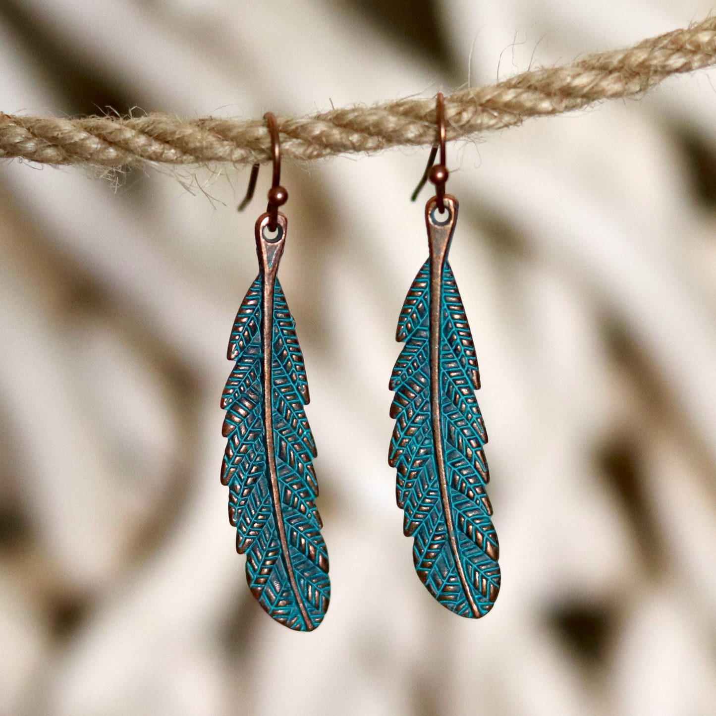 Bohemian-style feather earrings crafted with copper-toned metal